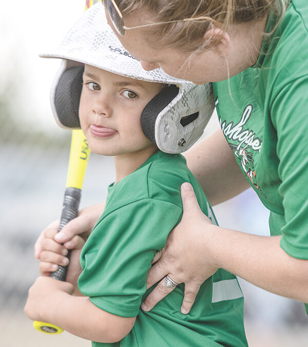 Oakln Doan gets hitting instruction from assistant coach Kelsey Nguyen as the Grasshoppers met the River Turtles in the T-ball division of Powell’s Little League. The players in the division are 4-6 years old.