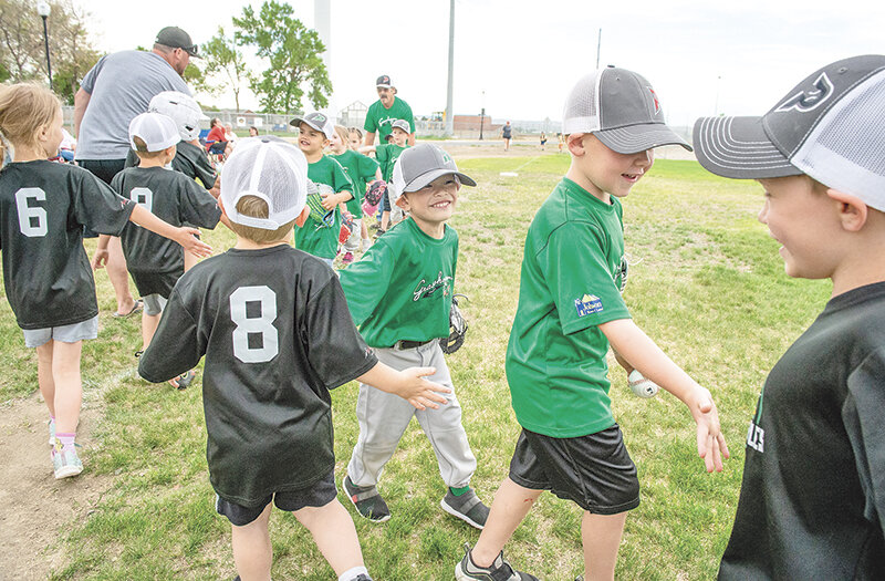 Grasshopper players meet the River Turtles at home plate after the game for high fives and a show of sportsmanship.