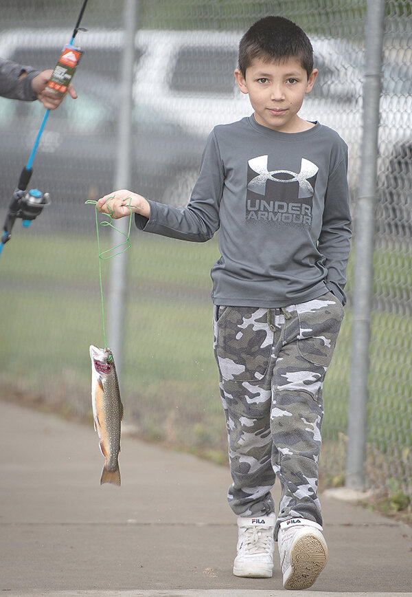 Mikey Holland, 7, harvests his first trout while enjoying fishing free of charge Saturday at Homesteader Park.
