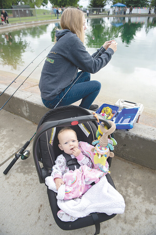Miley Olguin enjoys fishing with her sister, Brooke, before Brooke even reaches her first birthday. Kids’ Fishing Day has been celebrated for the past 37 years at Homesteader Park, giving families a chance to introduce fishing to their children.