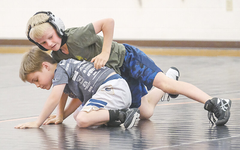 Hadley Allen (top) works on his positioning against Wyatt Ferrell during drills at the Powell High School wrestling camp last week.