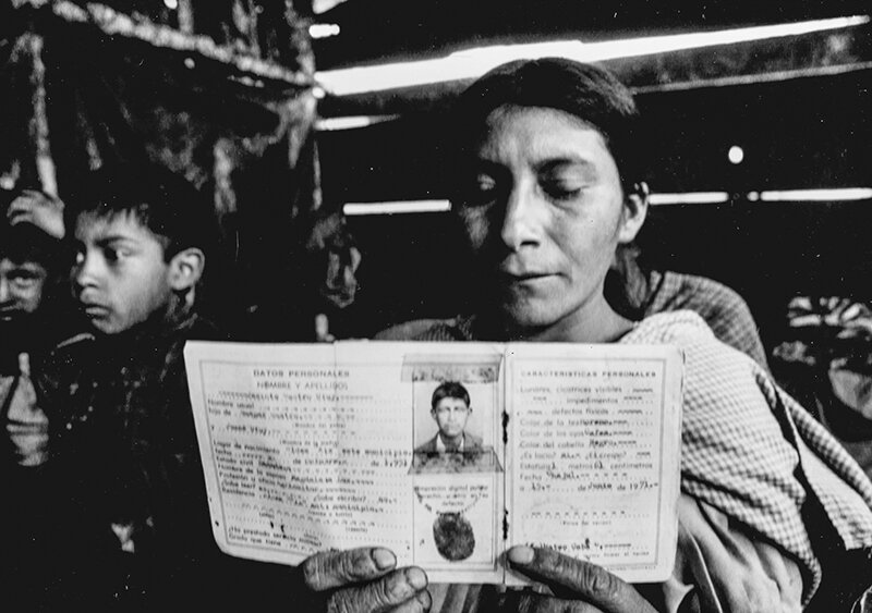Magdalena shows her husband’s work ID in hopes of finding news after he disappeared during the war near their village near Xix, Guatemala.