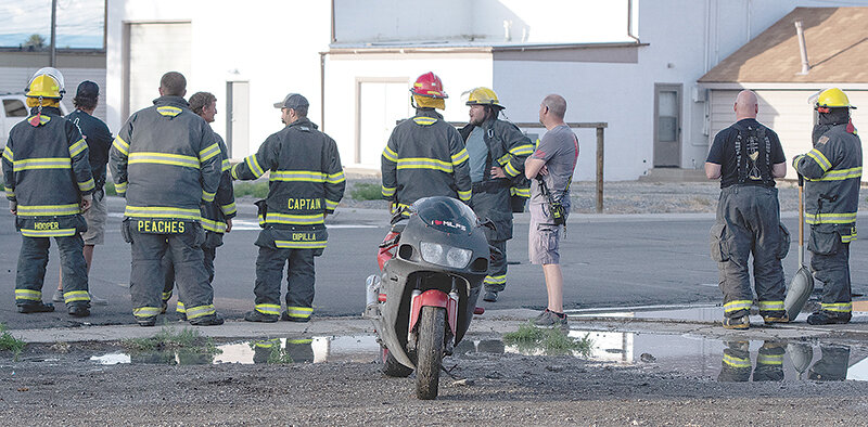 Members of the Powell Volunteer Fire Department stand by the scene of a June 3 motorcycle crash at the intersection of Ingalls and Third street. The driver of the motorcycle, Kirk Ohman, was allegedly fleeing from a police officer in an attempt to avoid arrest.