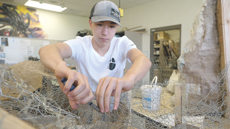 Homeschool student Trenton Kawano lays the wire work for what will become part of a diorama in the Viking exhibit.