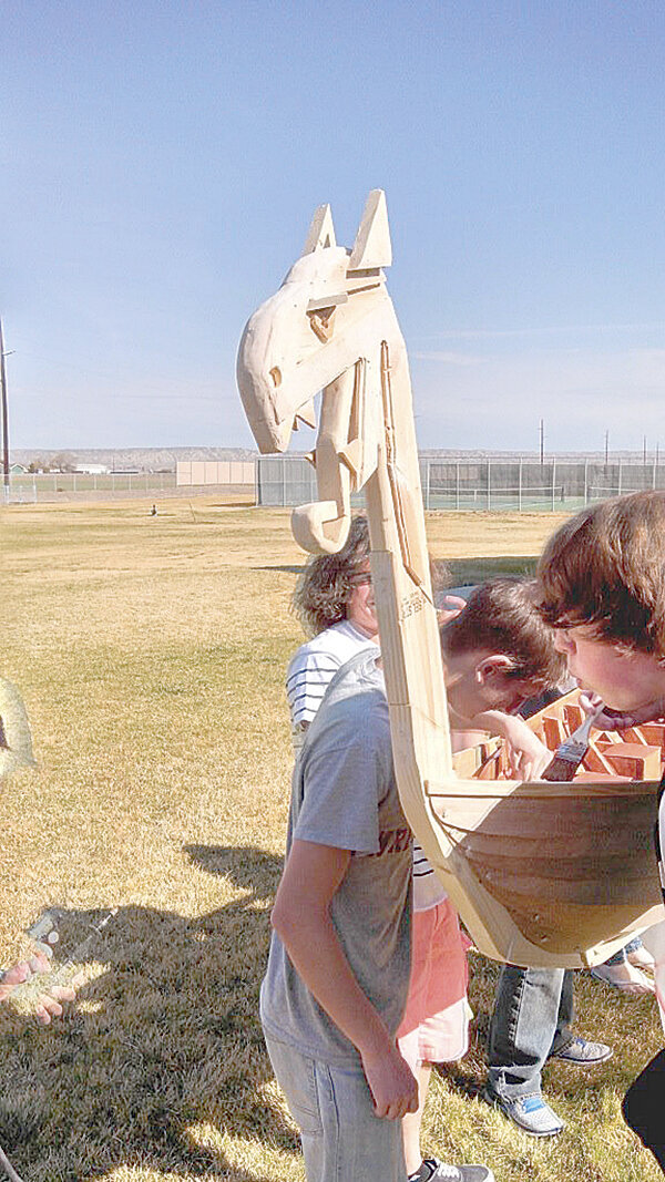 Powell High School students finish the wood on the original Viking longship in 2015.