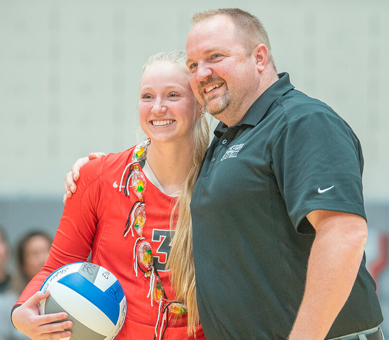 Ellie Thomas receives a ball signed by her teammates from coach Scott Keister after finishing with 20 digs in her final match. Thomas holds the all-time, single season and single game digs records at Northwest after two years as a Trapper.