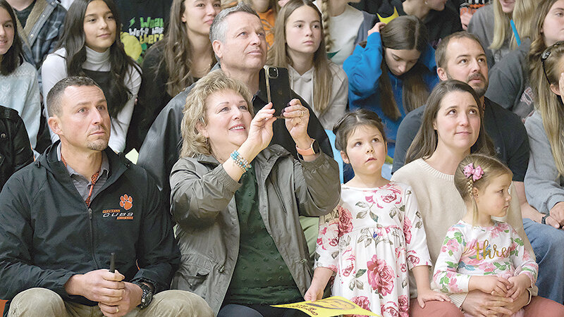 Chanler Buck’s family surprised him by sitting front row at the assembly held in his honor and together they watched a prerecorded message from Superintendent Jay Curtis and Assistant Superintendent Jason Sleep. From left, Chanler Buck, his father Stan Buck (behind), his mother Kim Hulse-Buck, his oldest daughter Margo Buck, wife Amy Buck and youngest daughter Remi Buck.
