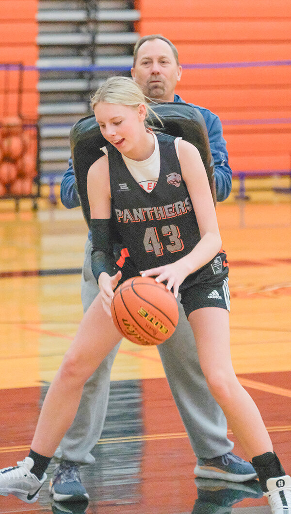 Junior varsity coach Troy Hildebrand helps push sophomore Hali Hancock during post drills as the Panthers open the season in Fremont County this weekend.