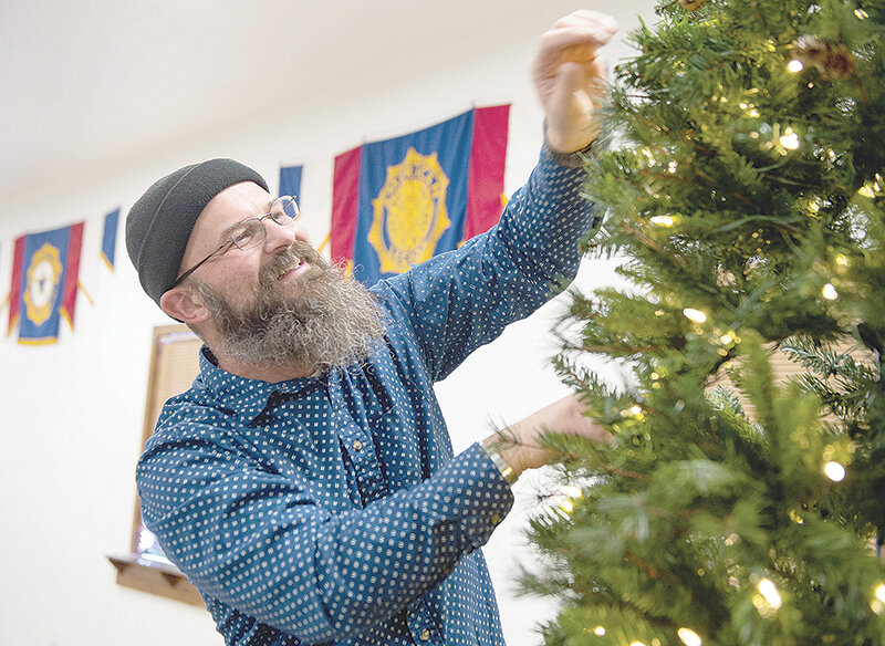 American Legion Hughes-Pittinger Post 26 Commander Tim Heine sets up of the Christmas tree in the assembly hall at the Post on Tuesday in preparation to a free public party with Santa on Dec. 16.
