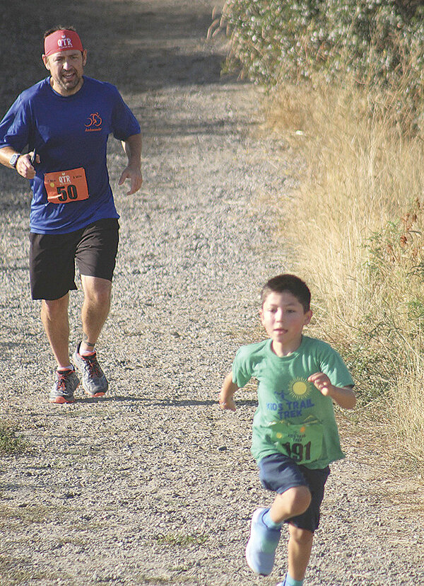 David Holland (left) is outpaced by his son Mikey during a trail run.