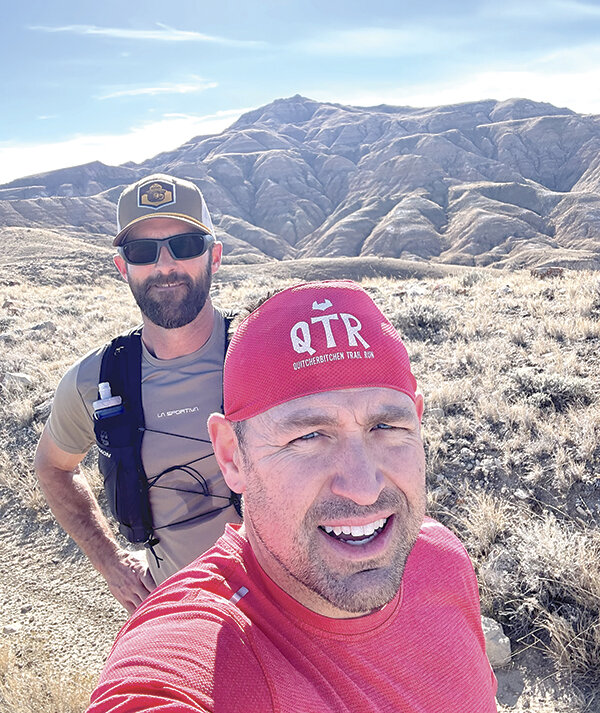 Brad Metzler (left) and David Holland pose for a picture after running to one of the highest points in the McCullough Peaks.