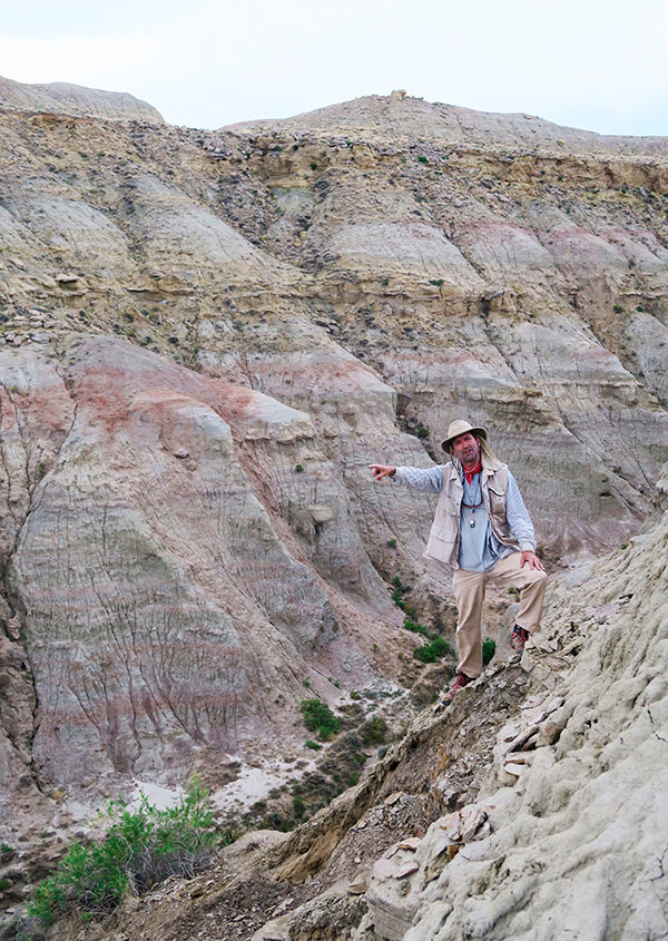 Dr. Scott Wing pointing at rocks deposited 56 million years ago during the Paleo-Eocene Thermal Maximum (PETM) episode.