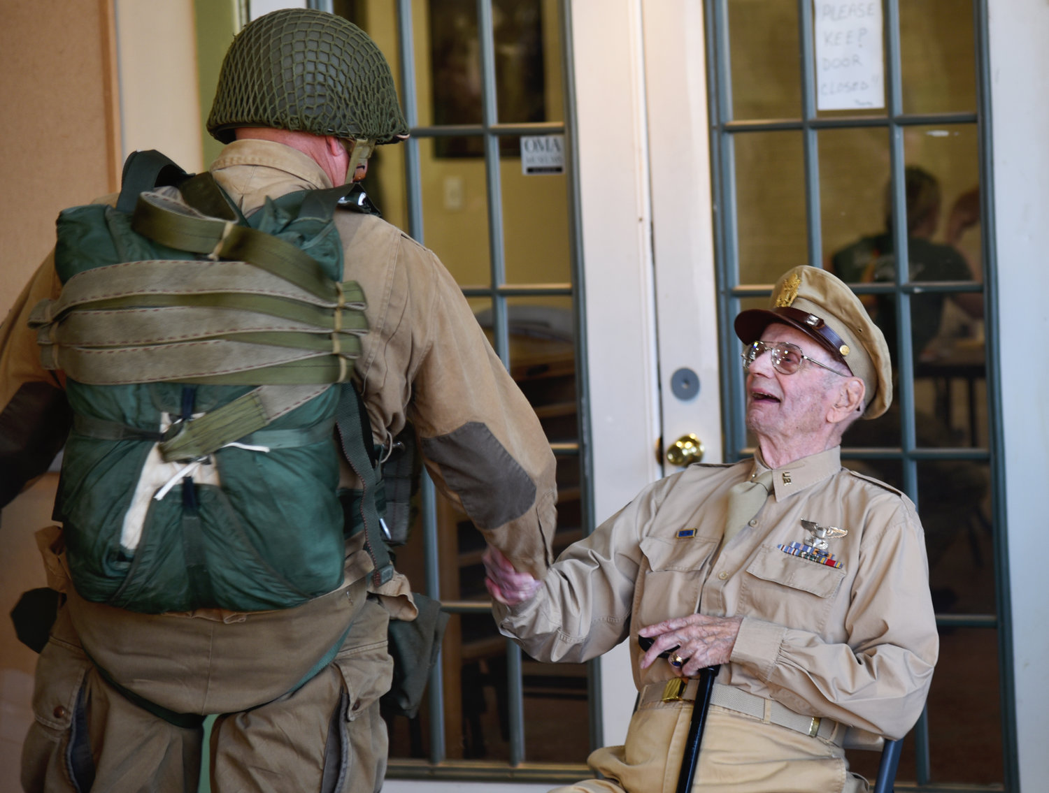 A World War II Airborne Demonstration Team member greets LTC Dave Hamilton, the last living World War II Pathfinder pilot, who celebrated his 100th birthday at Frederick Army Airfield July 16, 2022.
