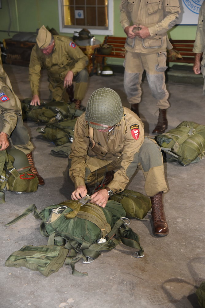 WWII ADT members check their gear before loading up to parachute from a WWII era C-47.