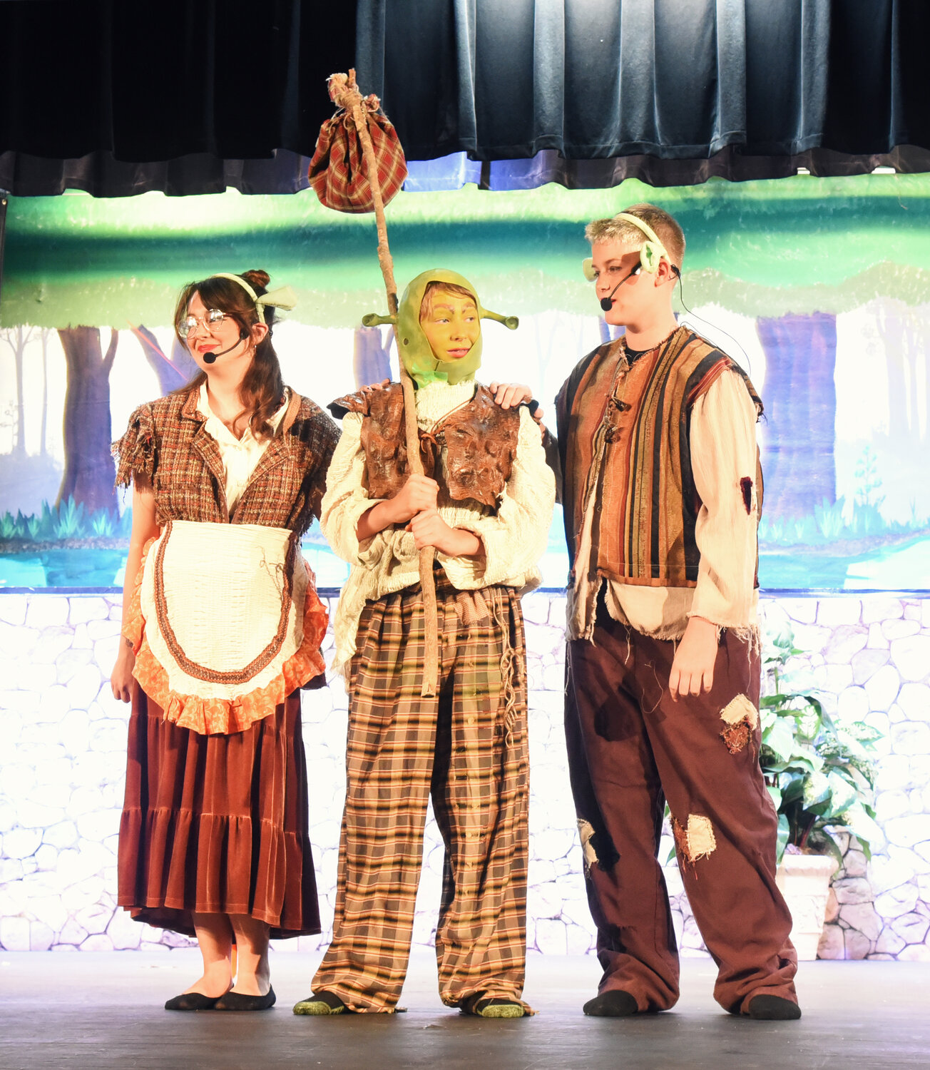 From left, Isabella Koch, Wiley Thornton, and Collier Johnson played Mama Ogre, Little Ogre, and Papa Ogre in Frederick Middle School’s production of Shrek the Musical, Jr.