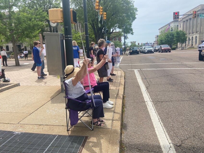 Members of Indivisible Jackson line up at the corner of Main Street and Highland Avenue in Downtown Jackson in front of Jackson City Hall and the Madison County Courthouse on Saturday, April 19, 2025.