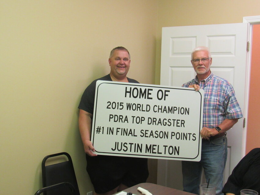 CHAMPION– 2015 World Champion Dragster Justin Melton is honored with signs that will be put at two different ends of the city of Gleason. Pictured is Melton along with Gleason Mayor Charles Anderson. Photo by CeCe Beckett.