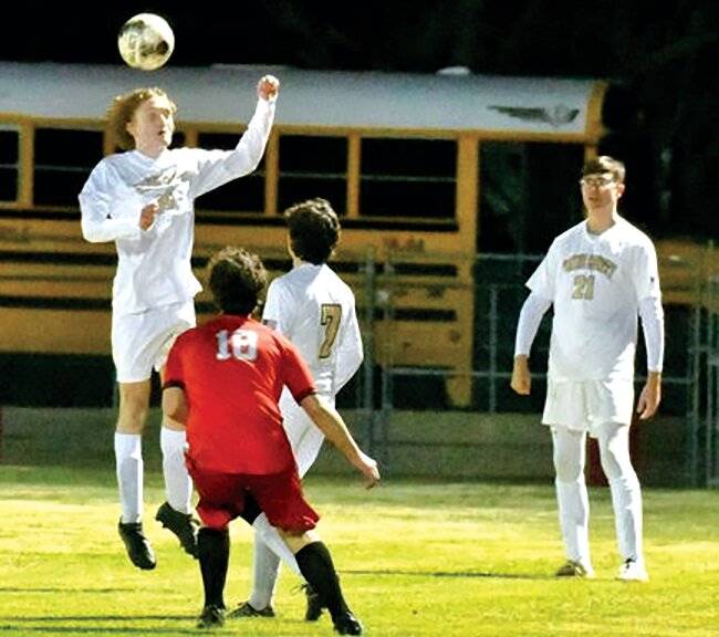 Daygen Smith heads the ball out.