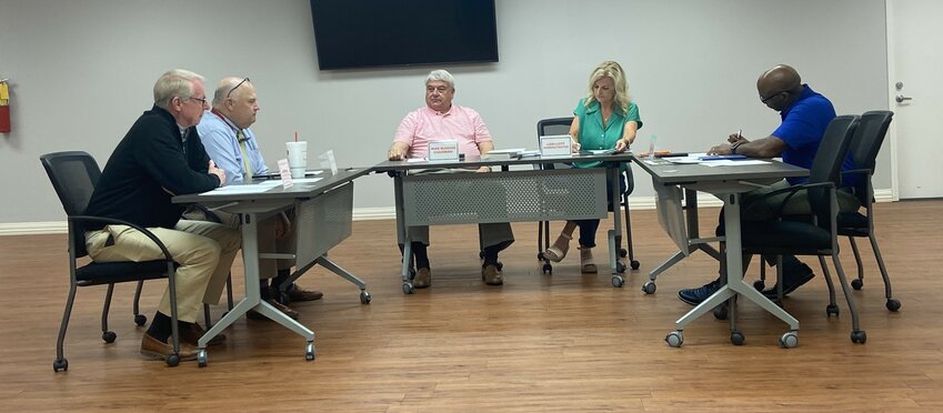 The current form of the Madison County Election Commission with three Republicans - Chairman Mike Bledsoe, Tim Wilson and Charles Byrd - and one Democrat - new Commissioner Dwight Jones - wrap up a brief meeting with Election Administrator Lori Lott on Thursday, April 24, 2025.