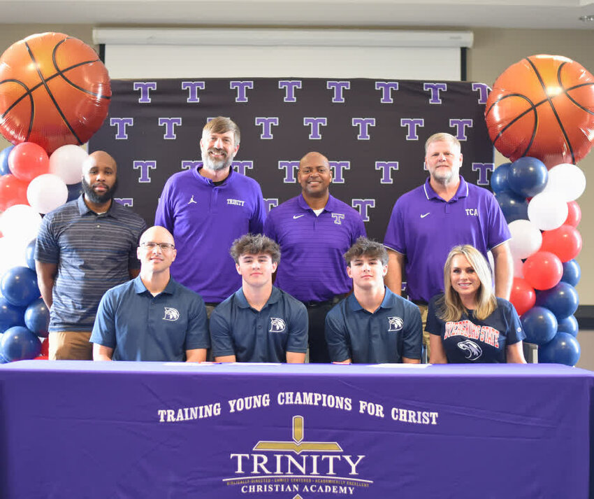 Drake and Cole Craddock sign their letters sending them to play basketball at Dyersburg State while their parents and coaches from Trinity Christian look on.