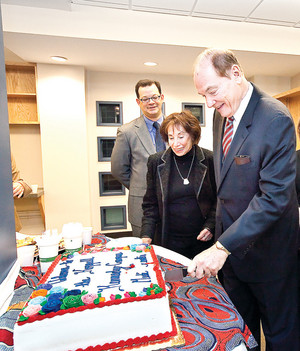 Councilman Oliver Koppell proudly cuts the cake celebrating the dedication of the G. Oliver Koppell Learning Center at the John F. Kennedy Campus on Tuesday. Councilman-elect Andrew Cohen and Eleanor Edelstein, the councilman&rsquo;s education liaison look on.