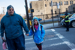 Michael And Gissele Garcia leave the St. Margaret of Cortona School on Riverdale Avenue at the end of the first day back to school after winter break on Monday.