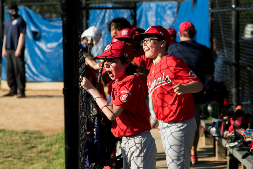 Nationals players cheer in the dugout during Game 3 of the North Riverdale Baseball League's major boys championship tournament. The Nationals beat the Yankees 7-5 to become champs.