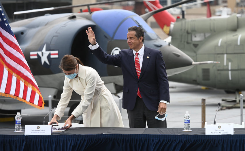 Gov. Andrew Cuomo waves to reporters after finishing his daily coronavirus briefing Monday from the USS Intrepid Sea Air &amp; Space Museum on Manhattan's Pier 86.