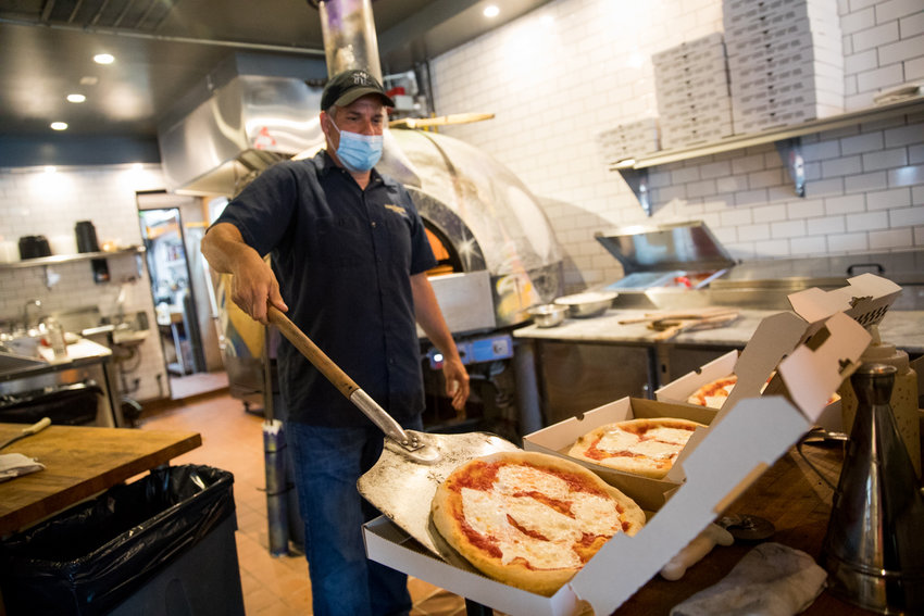 Christopher Giudice, co-owner of Kingsbridge Social Club, boxes a pizza for a customer&rsquo;s order. The Kingsbridge Avenue pizza joint is planning to offer more robust outdoor seating when the second phase of the state&rsquo;s reopening plan goes into effect for the city.