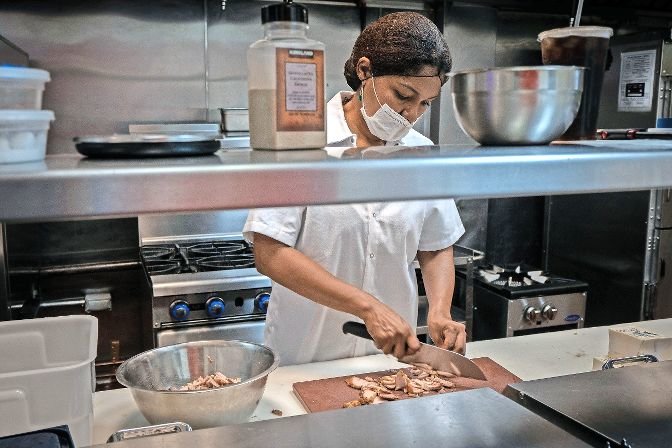 Claudia Berroa prepares food at Claudy&rsquo;s Kitchen, a Peruvian restaurant she has run with husband Richard at 5981 Broadway since last month. Opening a new restaurant can be challenging enough, but welcoming customers for the first time in the middle of a pandemic can&rsquo;t make it any easier. Yet, the couple says they have received a warm reception by the community.