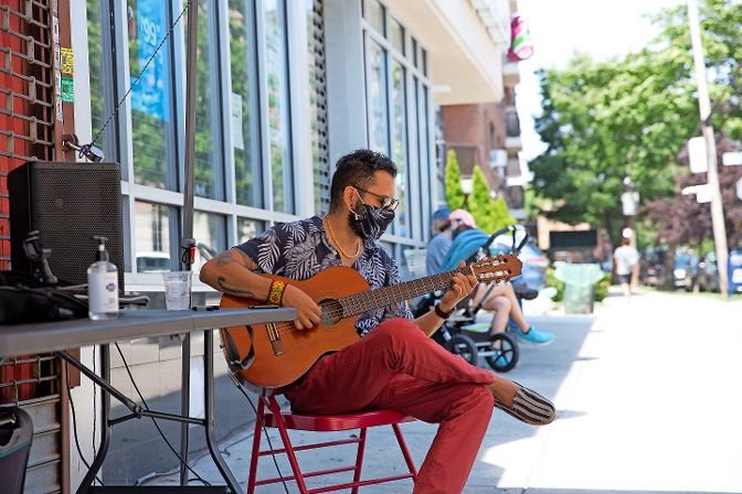 Sinhu&eacute; Padilla Isunza, a Bronx resident and career musician, performs on Johnson Avenue on Aug. 2, as part of the first Open Streets Sundays. The program, run by the Kingsbridge Riverdale Van Cortlandt Development Corp., blocks off streets so restaurants and artists can set up stands in a socially distanced manner.
