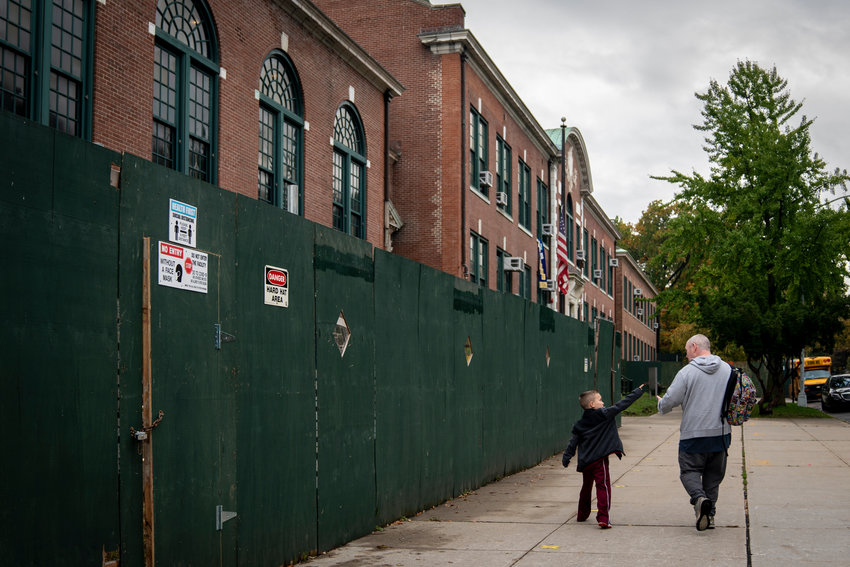 A father and son walk past P.S. 81 Robert J. Christen. Public school parents face a difficult decision in the upcoming days &mdash; should they opt for hybrid learning? If not, their children will remain remote for the rest of the academic year.