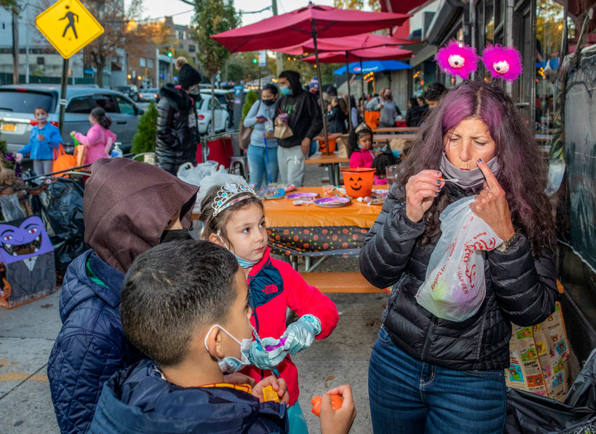 Cathy Sanacore teaches kids the trick to bubble-blowing at her socially distant Halloween party at Yo-Burger last weekend. Sanacore taught arts and crafts at Yo-Burger on Riverdale Avenue before the coronavirus pandemic, and used it as a site for a safe but fun Halloween party for neighborhood kids.