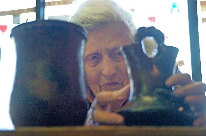 Shirley Egdal examines some of the merchandise that still remains on the shelf on her West 242nd Street store, Stop-In Country Shop, as she gets ready to close the doors for good in 2006.