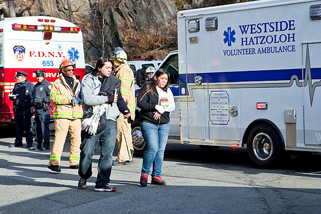 Victims of the Metro-North derailment near the Spuyten Duyvil station on Dec. 1, 2013, walk toward an ambulance on Edsall Avenue.