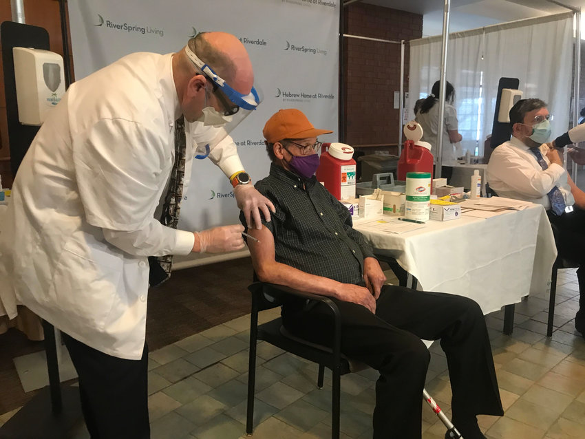 Kelley Dixon, 78, gets the first COVID-19 vaccine among residents at Hebrew Home at Riverdale from Walgreens pharmacist Mitchel Zaretsky on Monday morning.