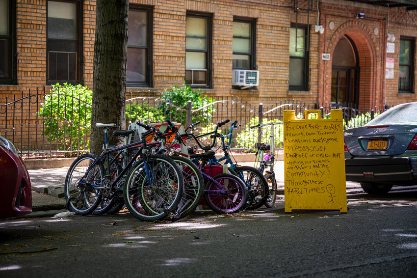 A collection of bicycles that is fixed and donated to those in need on the curb where cars park along Manhattan College Parkway on May 18.