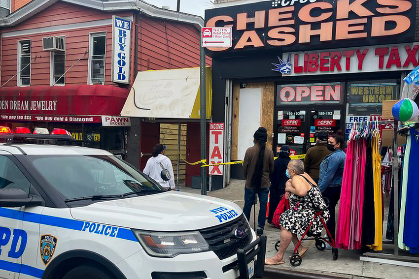 Customers wait outside the CFSC Checks Cashed shop at 189 W. 231st St. in Kingsbridge late last week. The shop was robbed just before sunrise on June 1 where some $46,000 in jewelry was stolen, according to the 50th Precinct. Perpetrators reportedly broke the left front window and removed the jewelry.