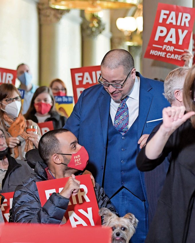 New York state Sen. Gustavo Rivera speaks to a disabled advocate at a press conference on fair pay for health aides and caregivers.