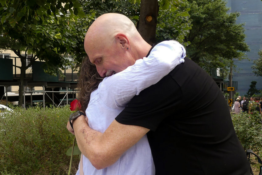 Jim Bradley embraces friends of his late wife ruth Mullen at rally for Ruth in Riverdale, NY on September 4, 2022.