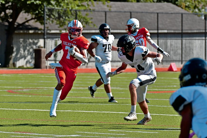 Fieldston quarterback Wes Heiman rushes past a Hackley defender during Saturday&rsquo;s home opener. He wound up with 115 all-purpose yards.