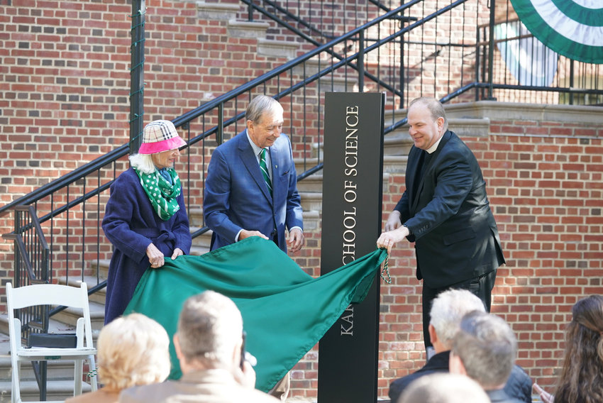 Aimee Kakos and Michael Kakos, unveil the sign announcing the Kakos School of Science at Manhattan College, as Brother Daniel Gardner, president of the college, helps out.