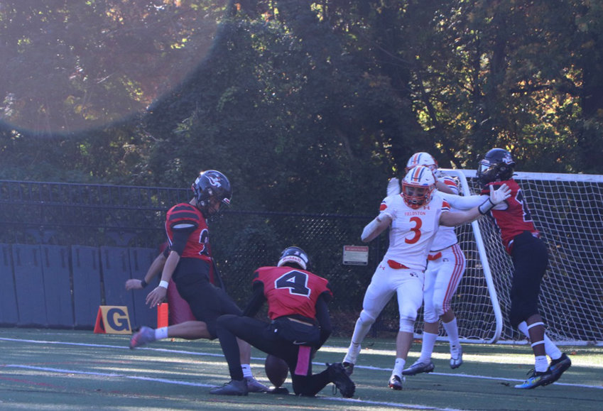 Henry Kaiden, a Fieldston junior, attempts to block an extra point from Long Island Lutheran kicker Ian Pagan during Saturday&rsquo;s playoff game in Brookville.