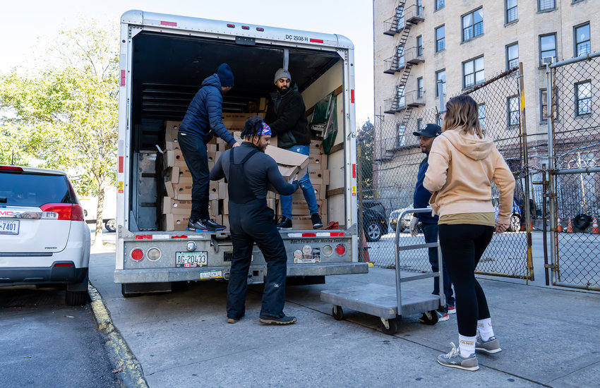 Members and volunteers with the Oyate Group unpack frozen turkeys from a truck at 3340 Bailey Ave. Tuesday morning. The turkeys were among 200 that the non-profit distributed to area organizations that will go to those who go hungry.