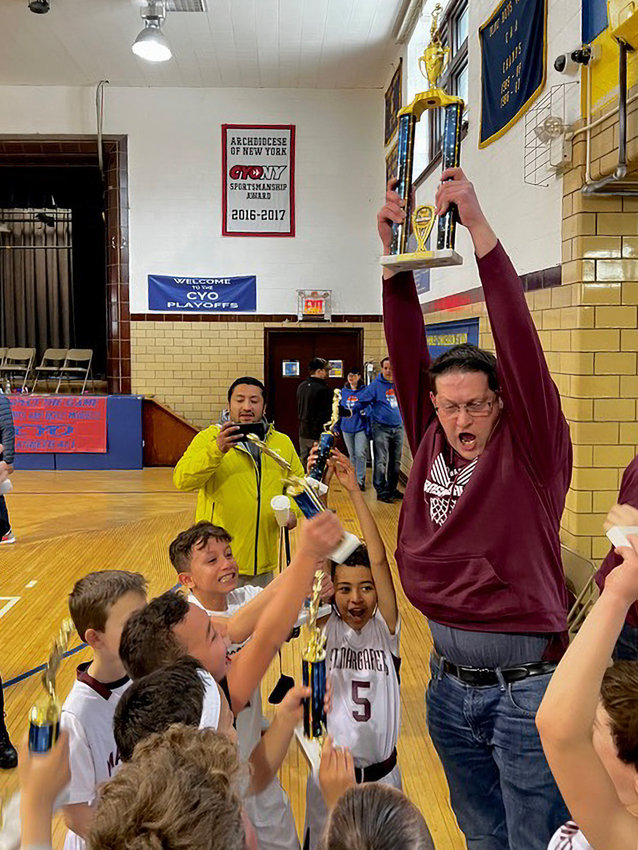 Saint Margaret head coach Sean Riley holds the CYO Bronx title trophy over his head Sunday in the 29-25 win over rival Saint Gabriel.