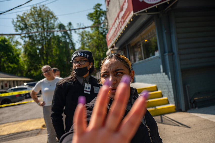 An  A&amp;H Security guard reaches for the camera in an uncomfortable scuffle with a photographer standing on the right-of-way in front of the Van Cortlandt Motel on Wednesday, May 10.