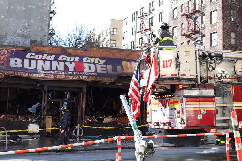 FDNY firefighters assess the damage to businesses after putting out a severe fire on West 231st Street in Kingsbridge early in the morning of Dec. 13.