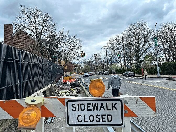 ERIC HARVEY  A man and his dog walk on the side of the road Friday, April 12. The south sidewalk of the Henry Hudson Parkway overpass at West 232nd Street is blocked off, as state transportation department contractors build a new bike lane.