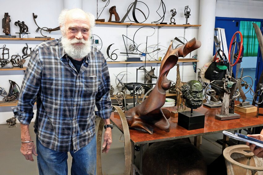 David Fischweicher, a sculptor from Riverdale, stands beside his abstract steel sculptures. The bust of a head on the table is of him and was done without looking in the mirror, Fischweicher said. The head was made out of clay, turned into wax and finally bronze.