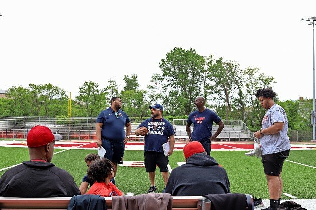 Head coach Alex Vega, center, discusses practice strategies with defensive line coach Oscar Martinez, left, and assistant head coach Howard Langley. The team typically runs practice for two and a half hours, including strength, conditioning and drills.